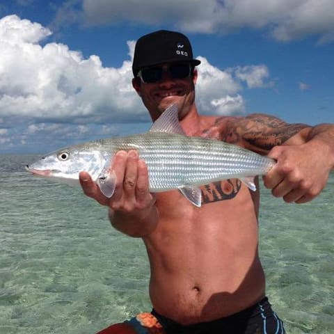 Angler holding a bonefish over the flats