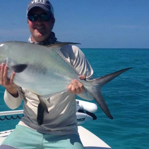 Angler holding a permit on the skiff